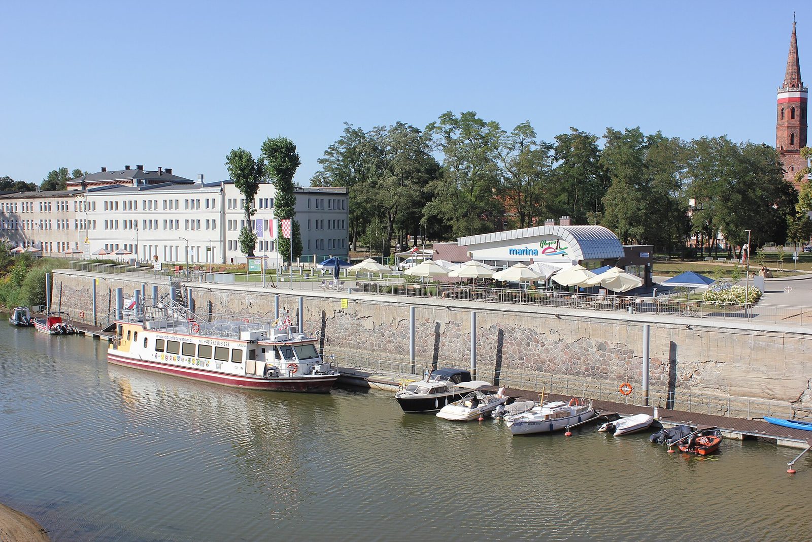 Marina nad Odrą w Głogowie ze statkiem wycieczkowym, w tle wieża kolegiaty