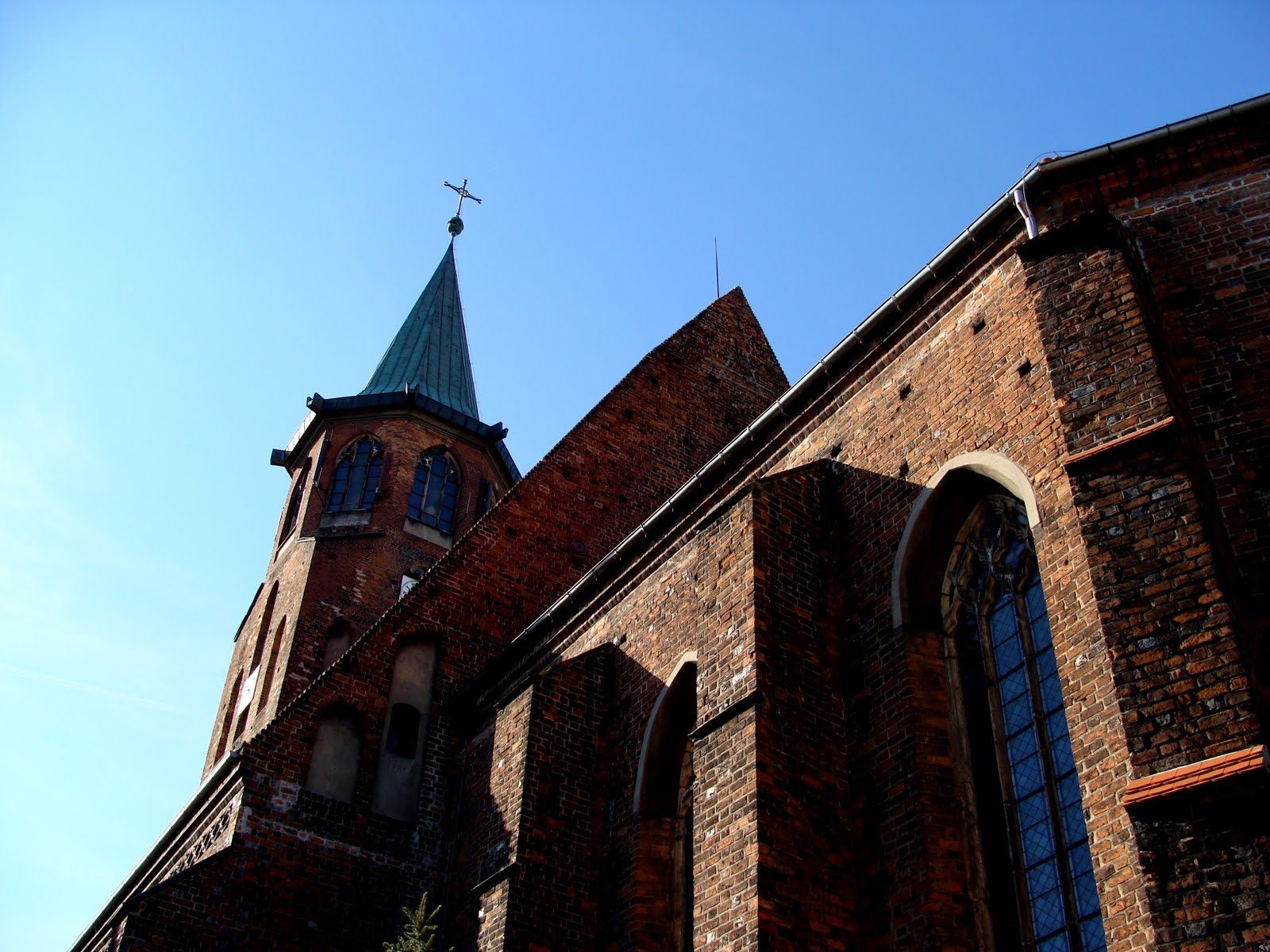 Ceglany gotycki kościół Podwyższenia Krzyża Świętego w Ścinawie z wieżą od strony zachodniej