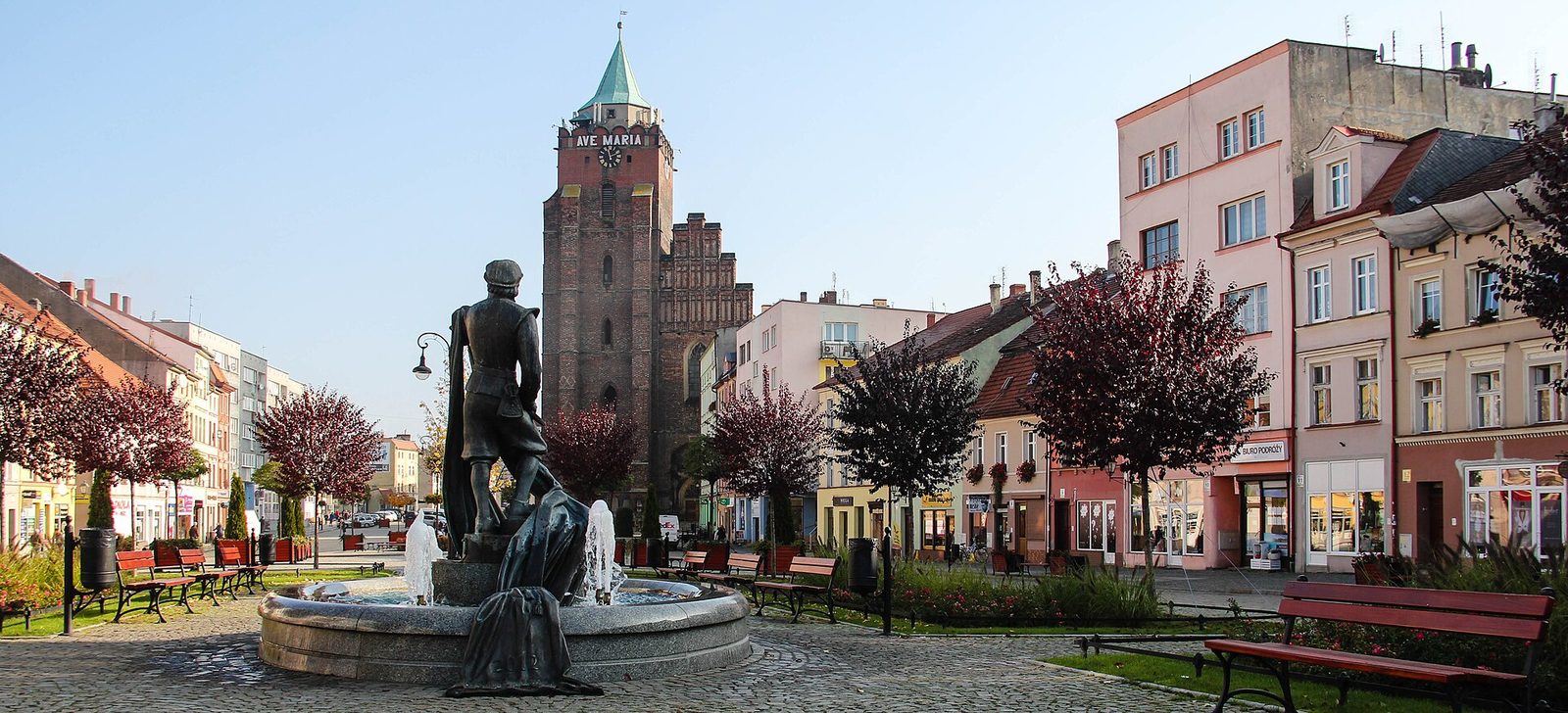 Panorama południowej i zachodniej strony Rynku w Chojnowie z kamienicami i fontanną na pierwszym planie
