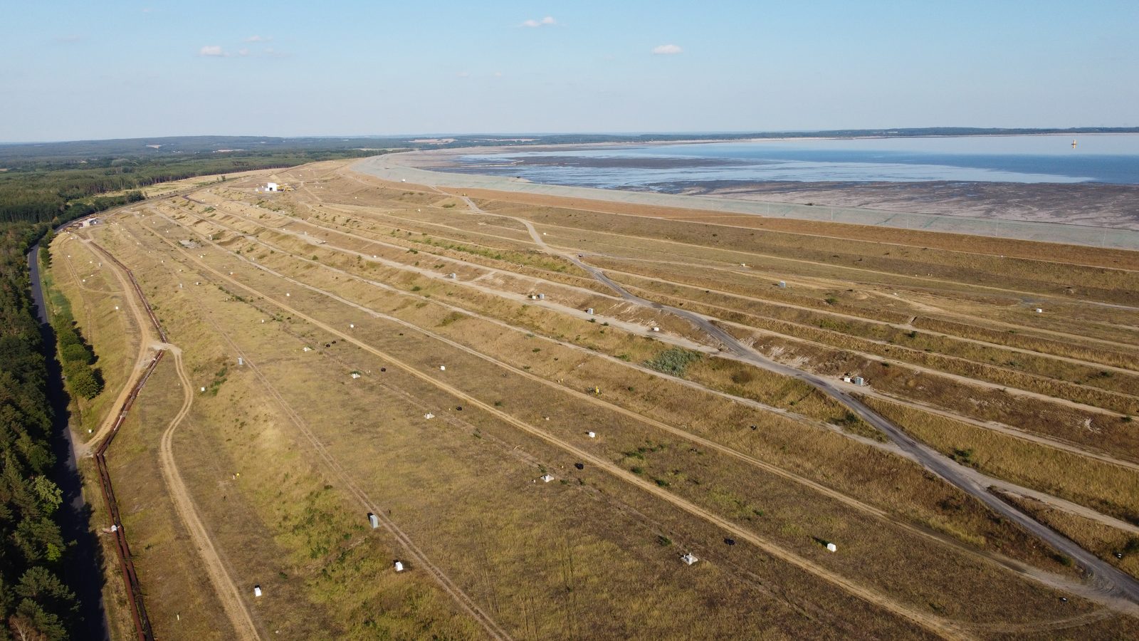 Zbiornik Żelazny Most z drona, 2 sierpnia 2022; pod plażą i wodą leżą dawne Barszów, Kalinówka i Pielgrzymów
